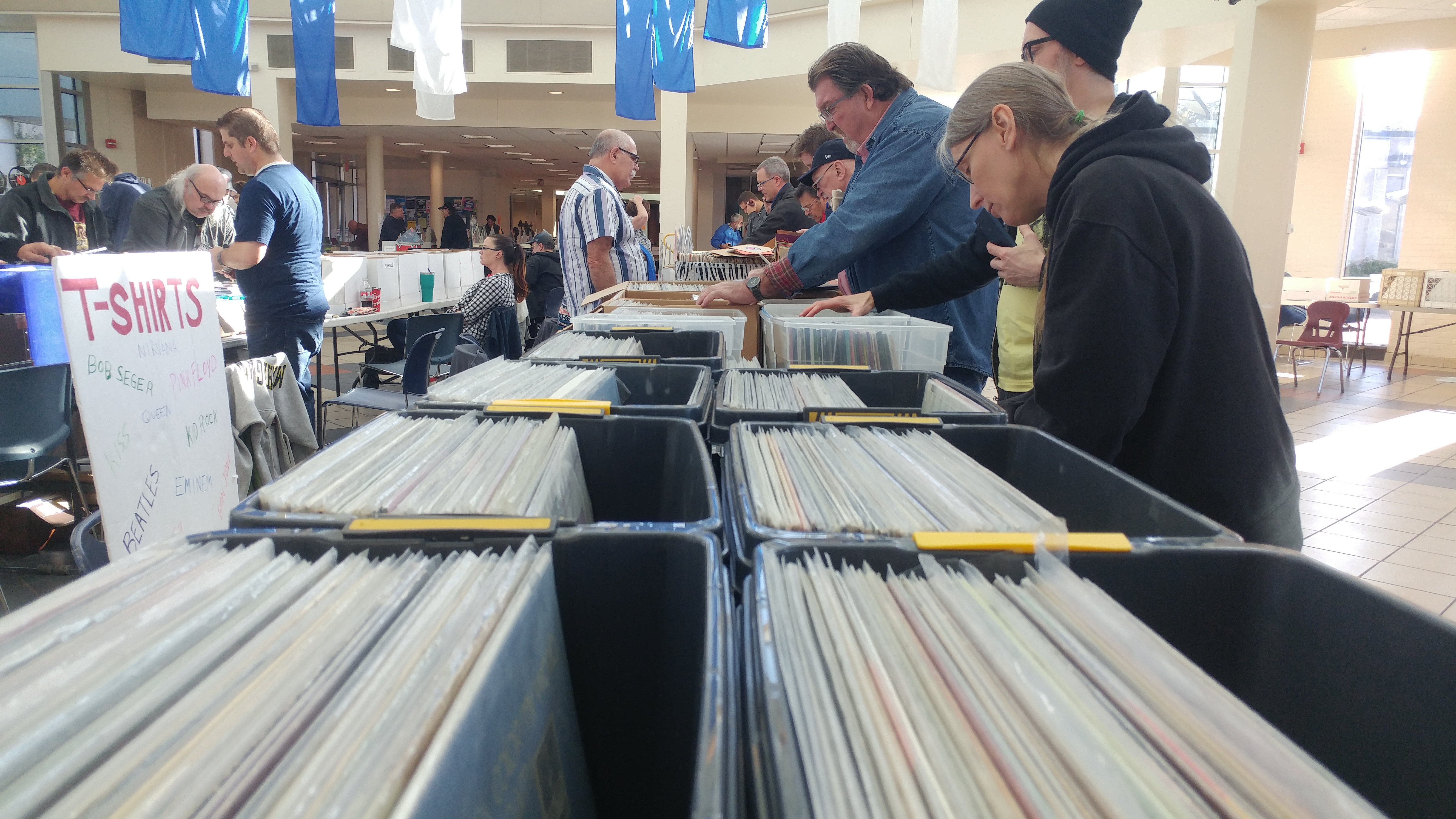 Photo shows several people looking through boxes of records