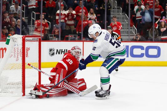 Detroit Red Wings Goaltender Jimmy Howard makes a save against Vancouver Canucks Center Bo Hovart during a shootout at Little Caesars Arena