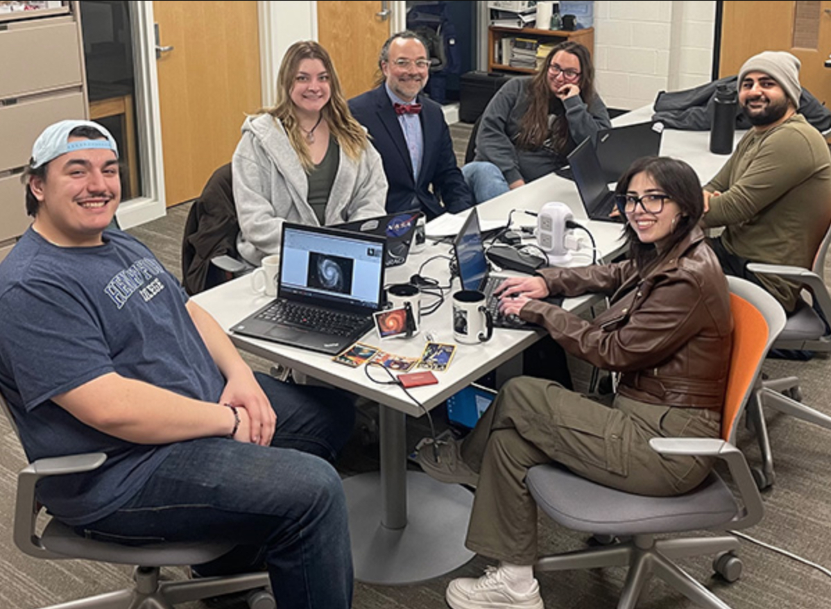 HFC physics and astronomy instructor Jesse Mason (center, wearing a bowtie) is surrounded by his student research group called the Dead Stars Society. Photo courtesy of HFC Marketing HFC physics and astronomy instructor Jesse Mason (center, wearing a bowtie) is surrounded by his student research group called the Dead Stars Society. Photo courtesy of HFC Marketing