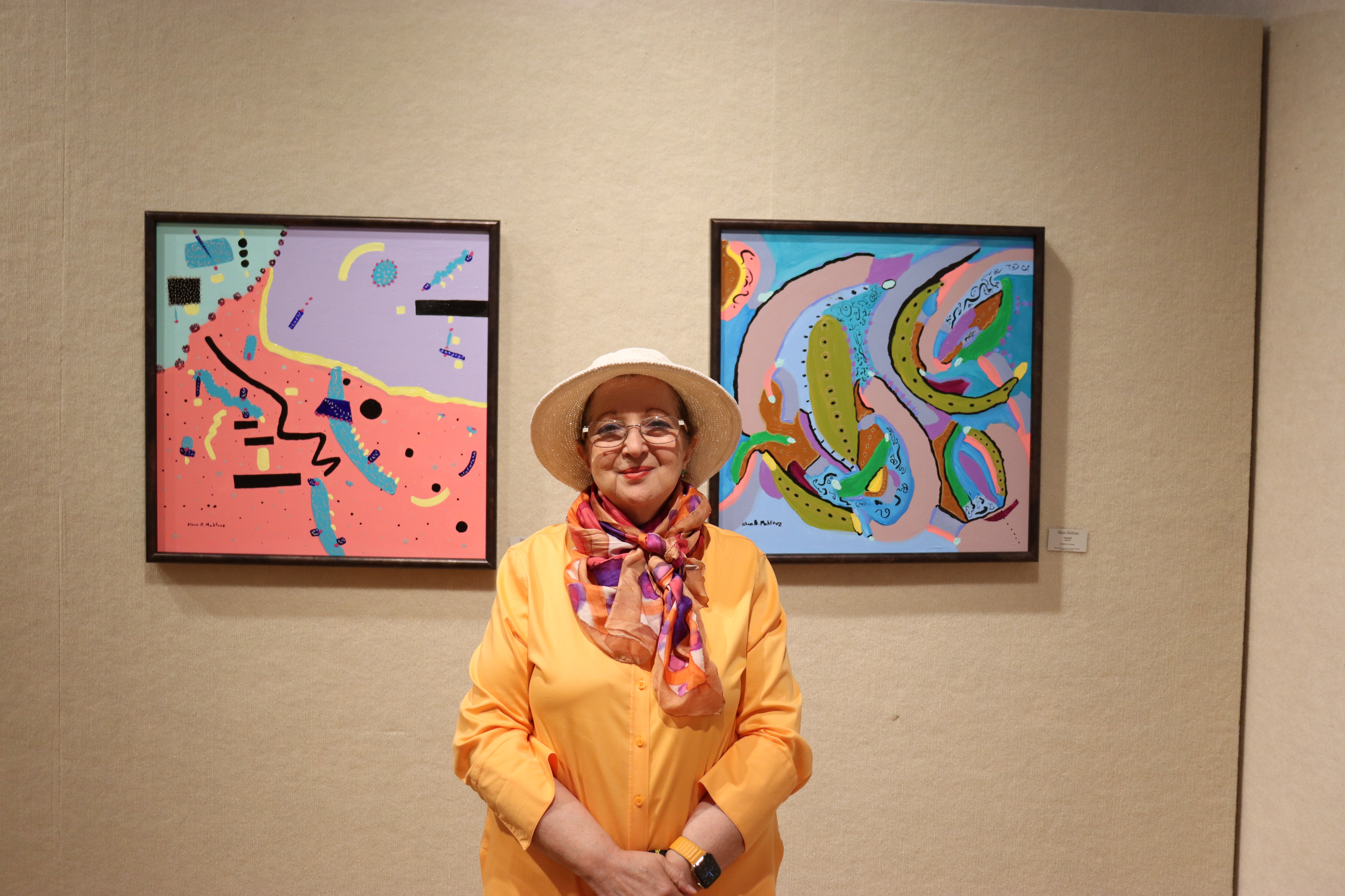 Ilham Mahfouz in front of her artwork on display as part of “For the Love of Humanity” exhibit, Padzieski Gallery in Dearborn, MI. Photo by Zynab Al-Timimi