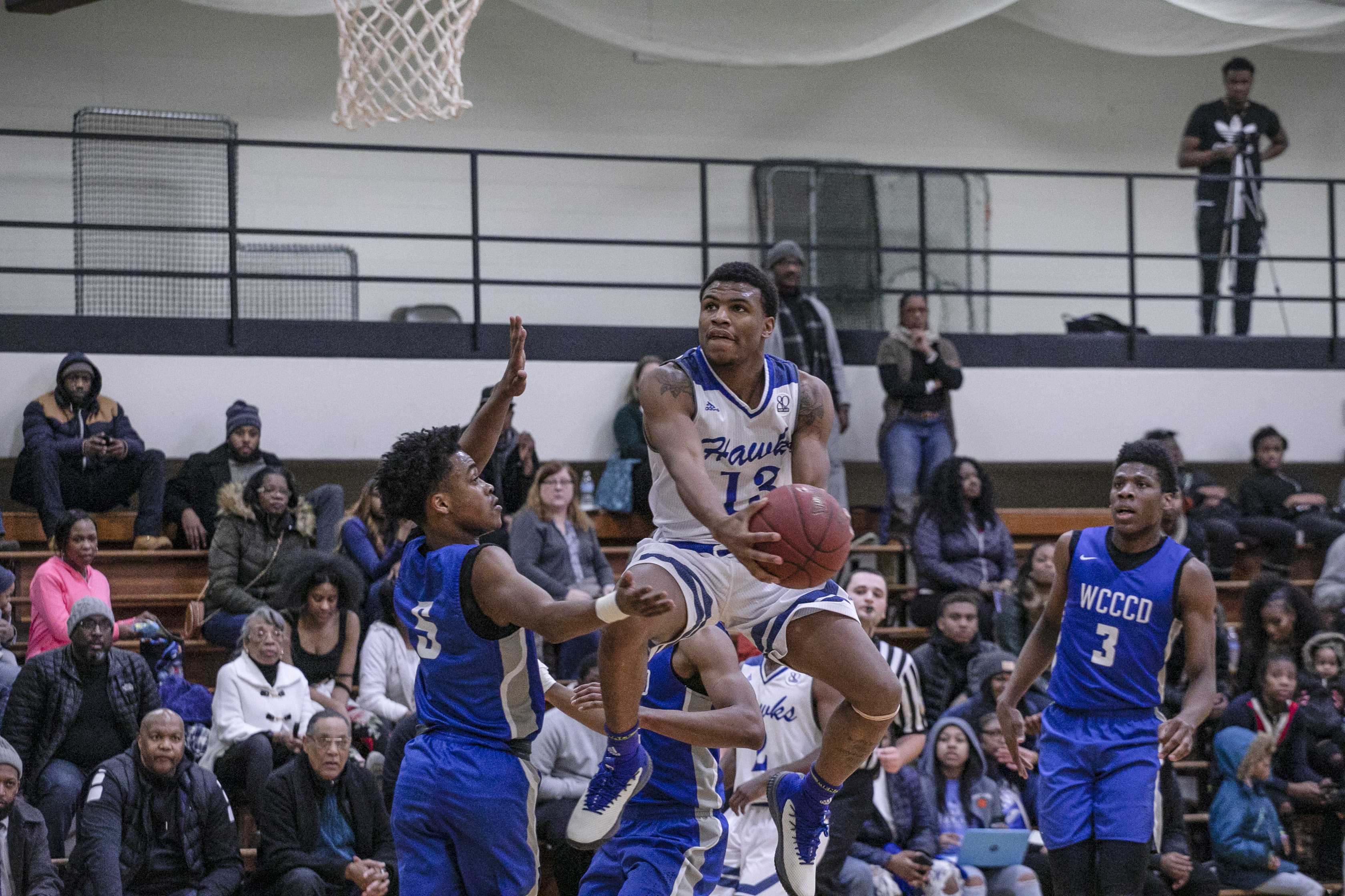 HFC's Luster Johnson driving to the hoop for a reverse layup with a defender on him