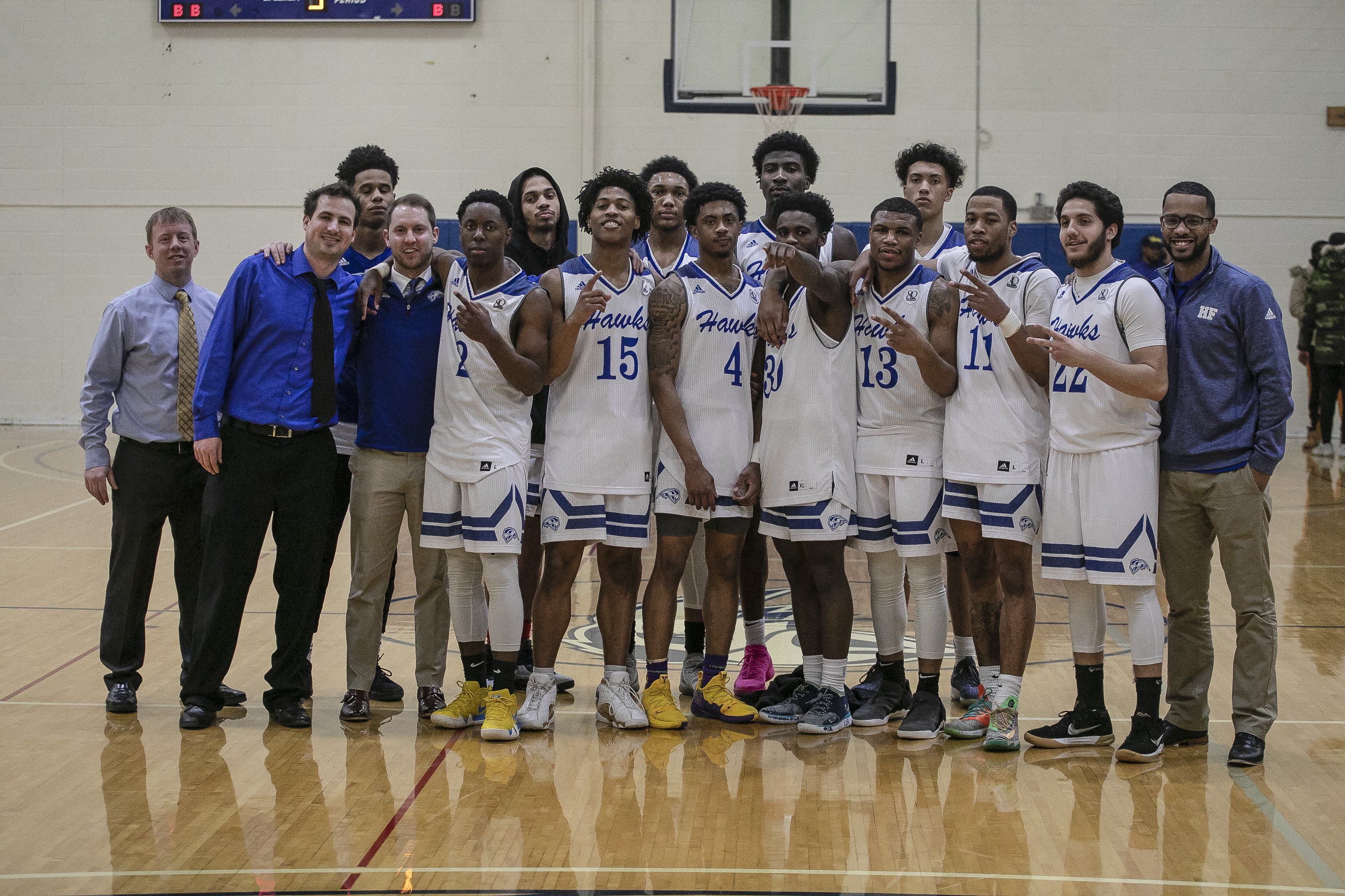 Henry Ford College men’s basketball team celebrating after winning against St. Clair College