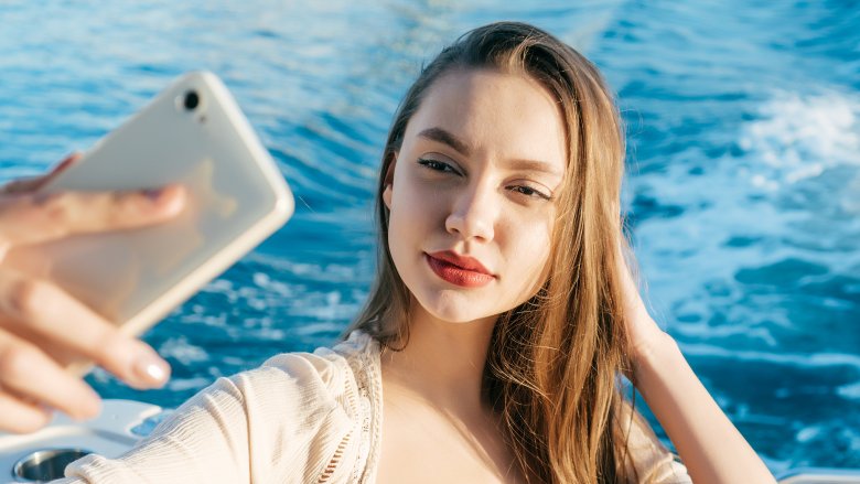 Image shows a young woman taking a selfie
