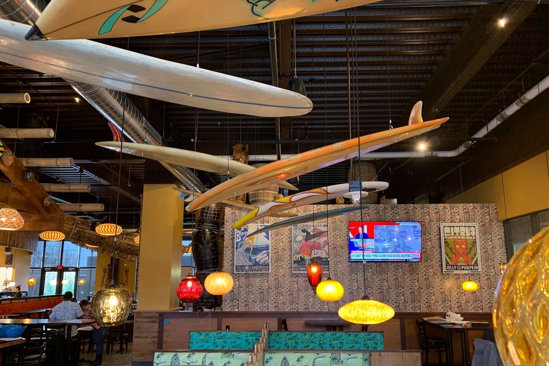 Photo of Longboard's interior decor, including surfboards hanging from the ceiling and a vibrant setting