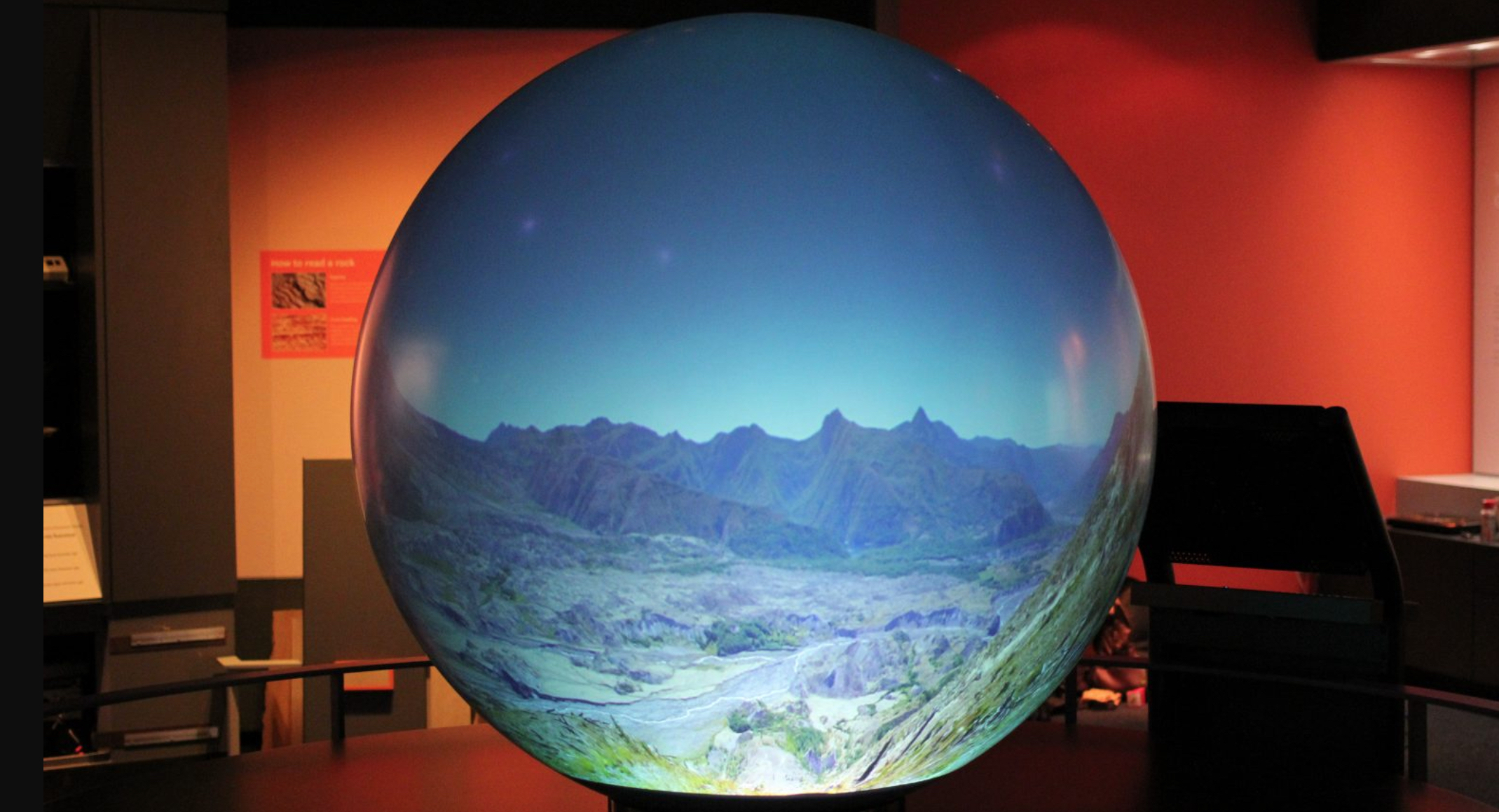 Image of a working Magic Planet device showing a mountain landscape photograph