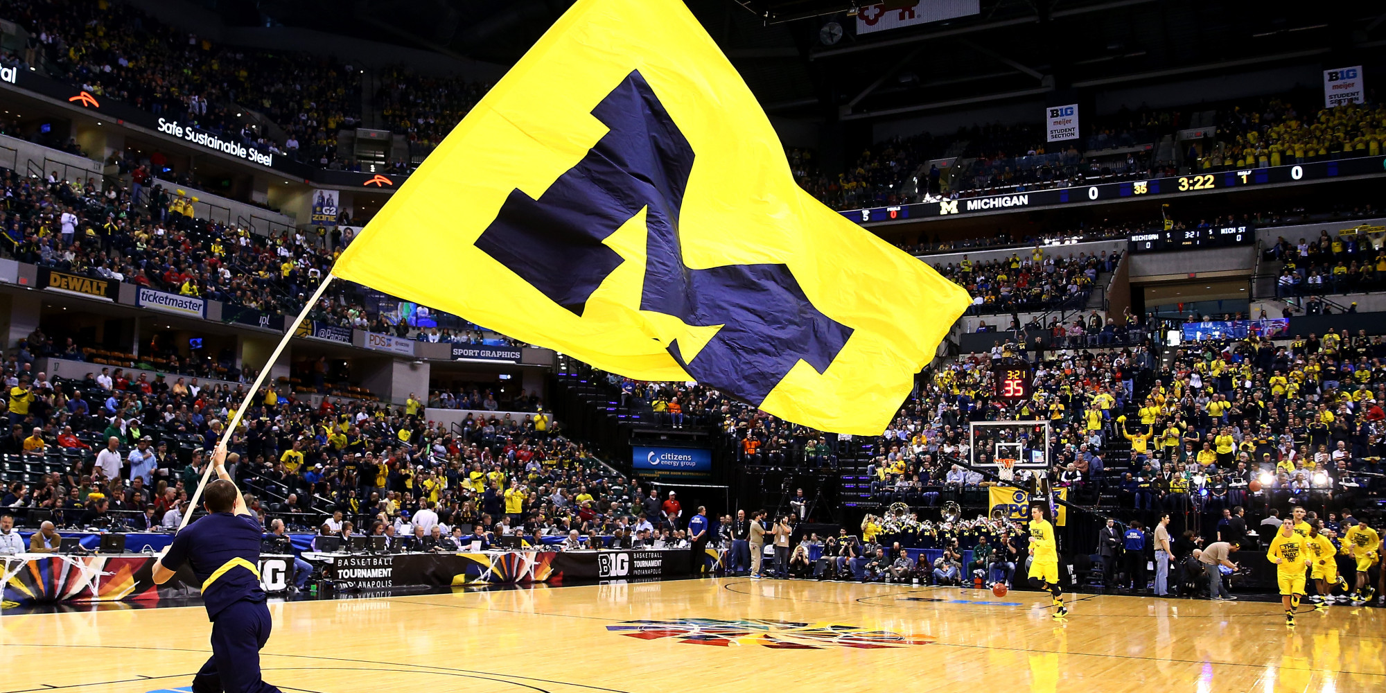 University of Michigan flag paraded on basketball court before NCAA tournament game. 