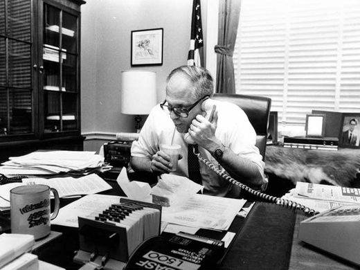 Black-and-white photo of U.S. Representative John Dingell on the phone