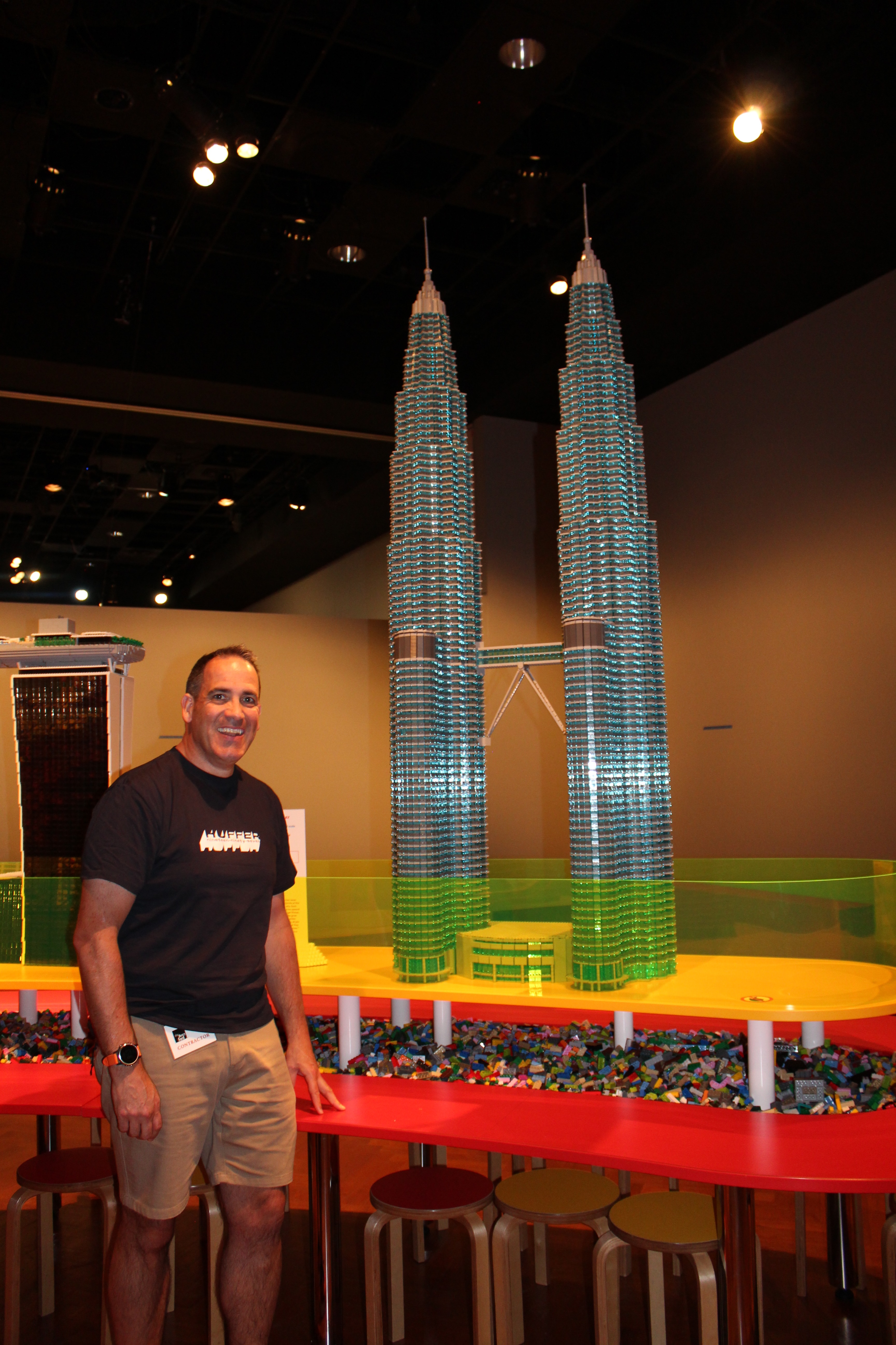 Photo shows Ryan McNaught standing next to a lego replica of the Petronas Towers