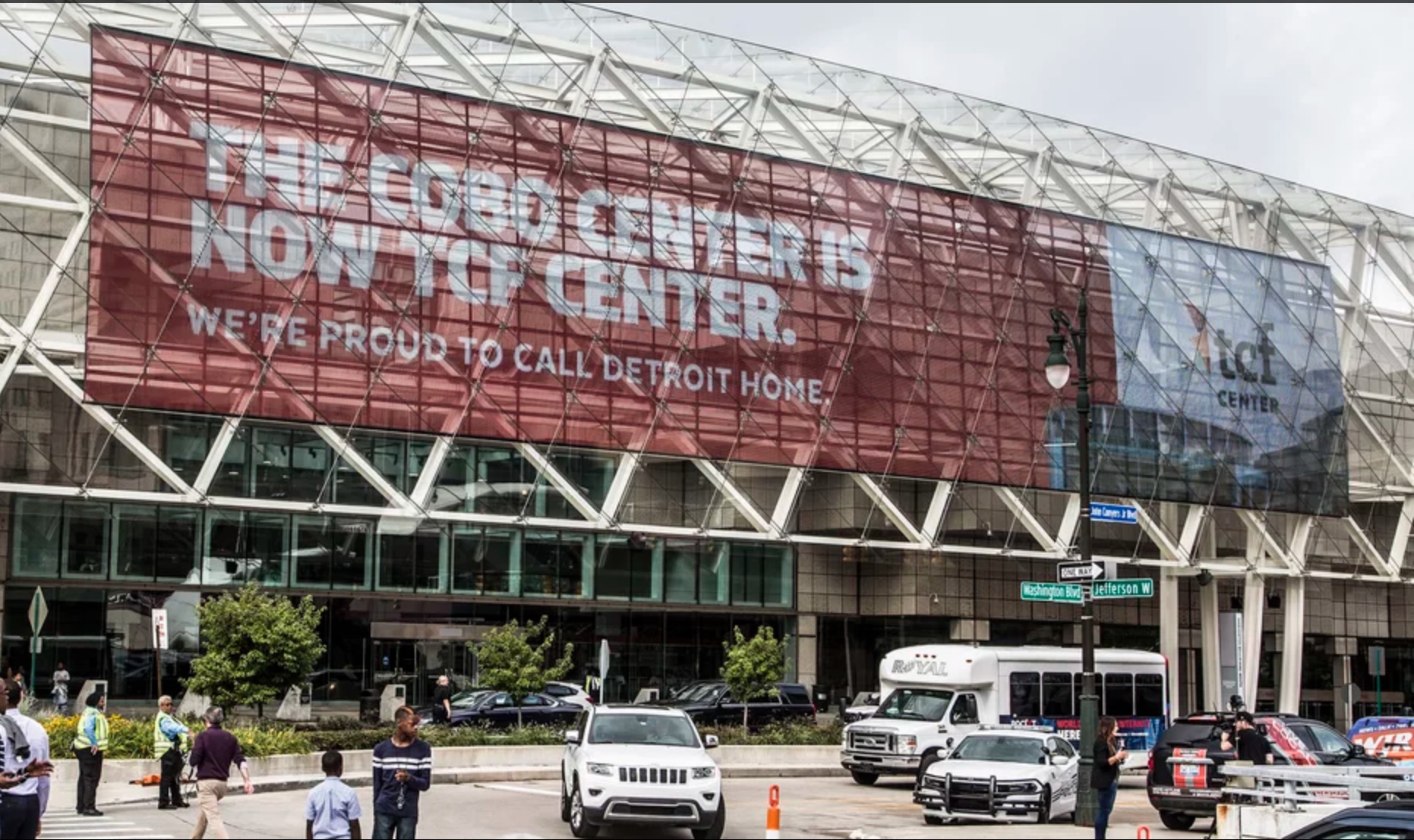 Image shows a red banner across the TCF Center reading, "The Cobo Center is now TCF Center. We're proud to call Detroit home."