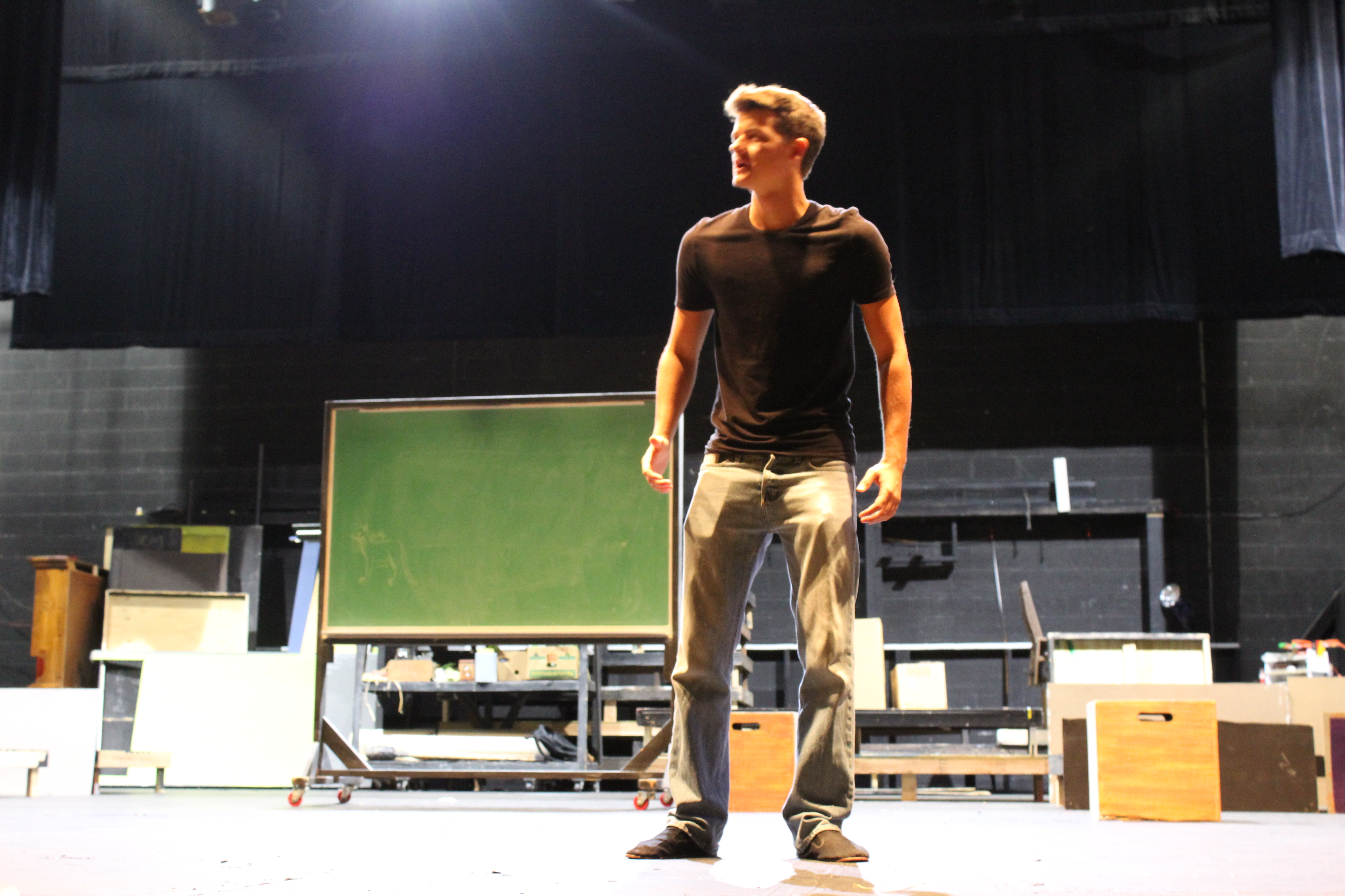 Photo of rehearsal with Dakota Nuttall on stage practicing a line.