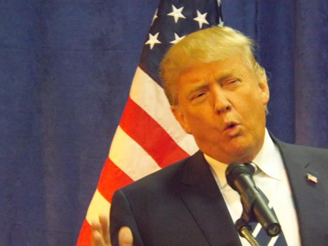 Presidential Candidate Donald Trump stands in front of an American flag.