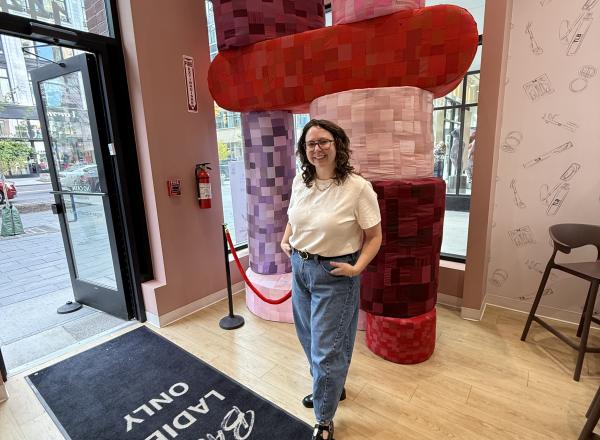 Artist Libby Priese standing in front of her sculpture in The Lip Bar, Detroit.