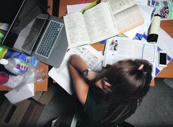 Stock image of student with messy desk. Photo courtesy of The Odyssey