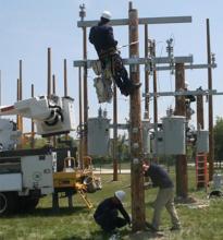 Photo shows student electricians working on an electrical pole
