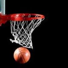 Basketball going through a basketball net. 