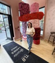 Artist Libby Priese standing in front of her sculpture in The Lip Bar, Detroit.