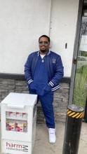 Charles Brooks, president of Phi Theta Kappa, standing behind Narcan dispansry at Henry Ford College, dearborn MI