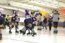 Women playing in a roller derby game.