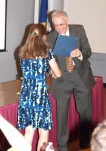 Dr. Michael Daher handing an award to a student