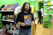 Image shows Saladin Ahmed holding a copy of Ms. Marvel #13 at Green Brain Comics